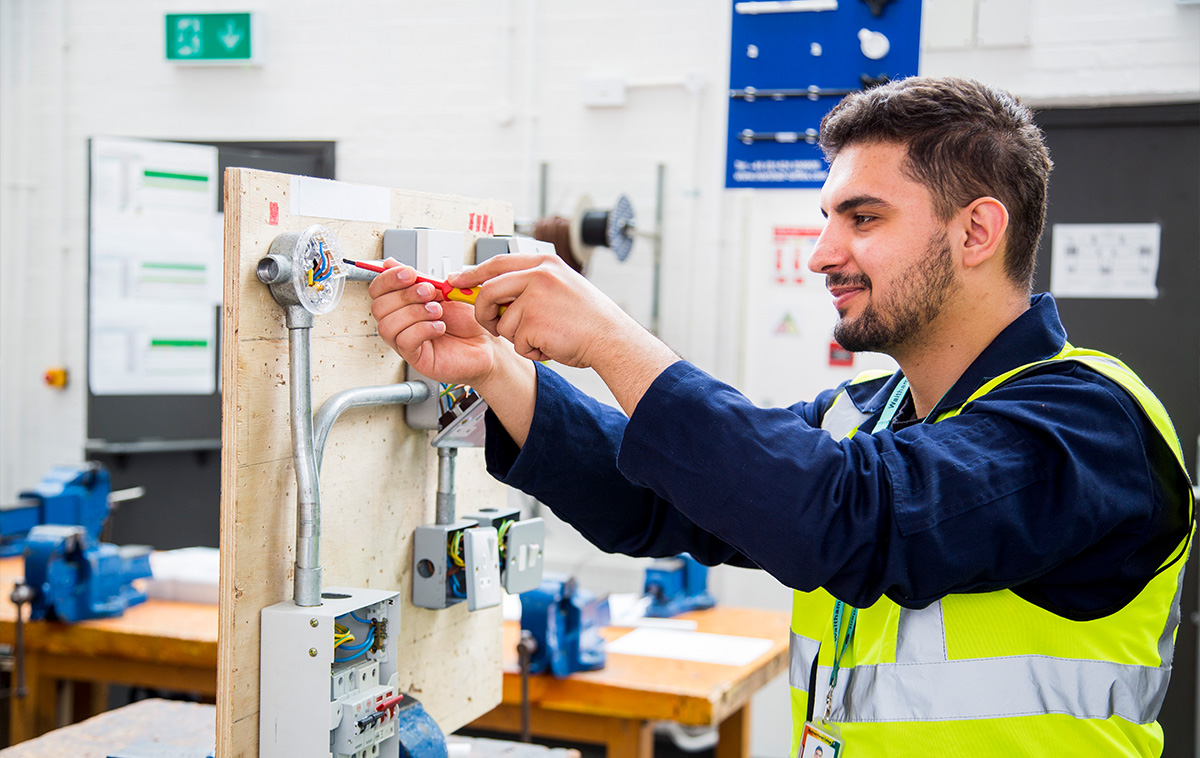 Student using screwdriver to tighten electrical components
