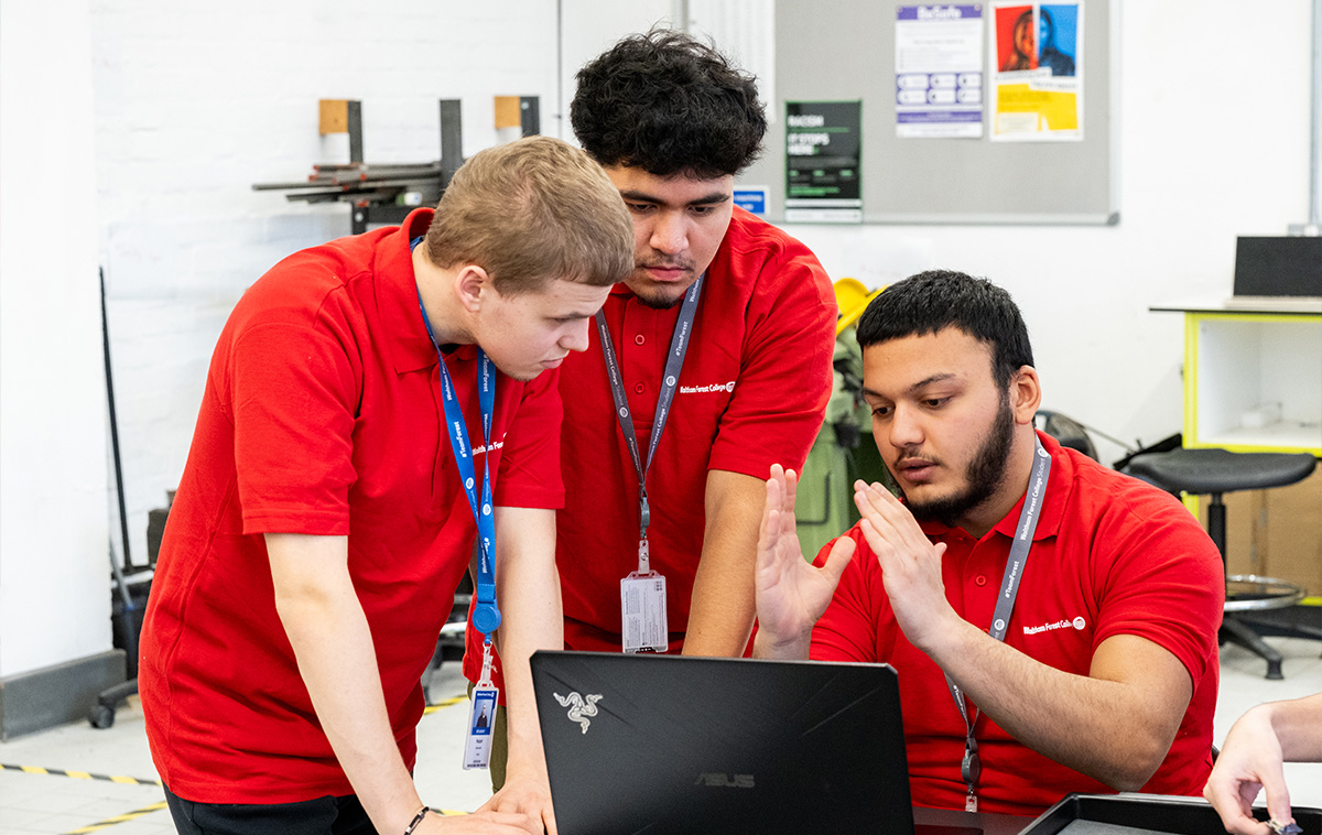 BTEC students discussing school work by a laptop