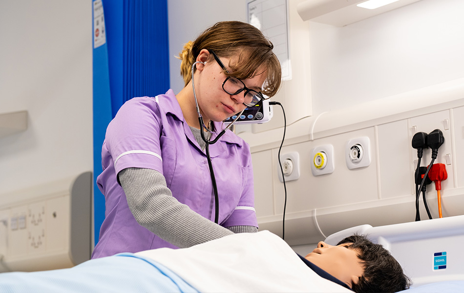 Healthcare student tending a dummy patient