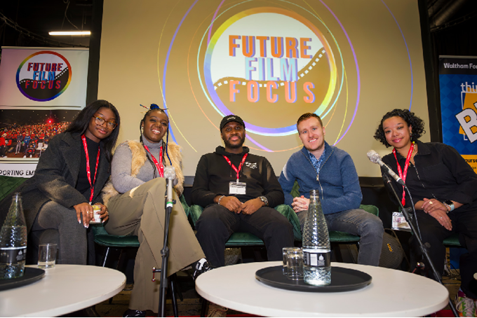 Panelists pose for camera on stage