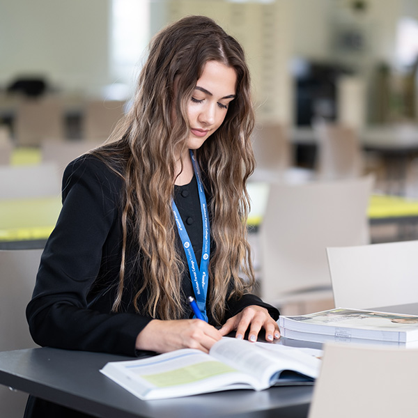 Student studying a coursework book about business